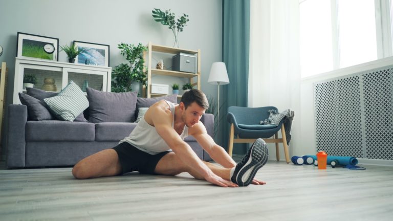 a man sitting on the floor with a pair of shoes